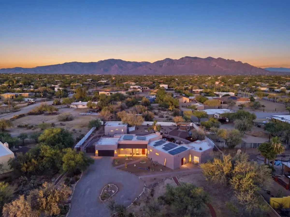 Aerial view of a Tucson home and neighborhood with mountains beyond